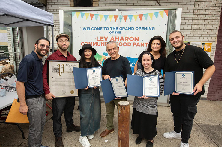Simon Sebag distributes citations of recognition to Lev Aharon Community Food Pantry volunteers Israel Peskowitz, Angela Zhang, Amnon Baruch, Tova Morgenstern, ALiza Simantov, and Aviv Simantov.